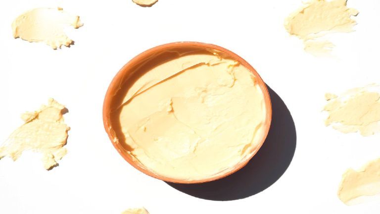 Sentar planas de una olla de manteca de karité con muestras de productos
