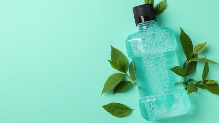 Botella de enjuague bucal sobre fondo azul.