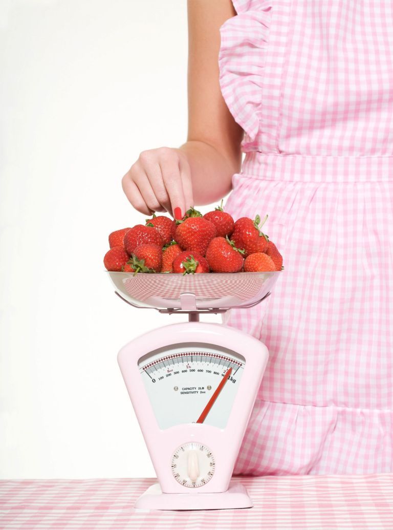 Frau-wiegt-Erdbeeren Foto