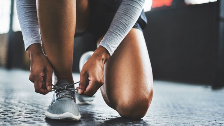 Wie lange halten Laufschuhe: Frau beim Schnüren von Turnschuhen
