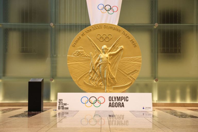 TOKIO, JAPONIA – 2021/07/21: Reprodukcja na dużą skalę złotego medalu Tokio 2020 na wystawie na Agorze Olimpijskiej. Agora olimpijska w dzielnicy Nihonbashi to projekt artystyczny, który ożywia starożytną grecką ideę zbiegu sportu, sztuki i kultury.
