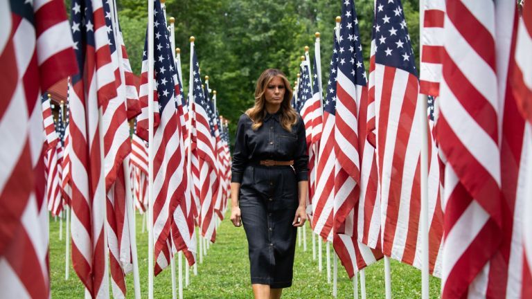 TOPSHOT - La Primera Dama de Estados Unidos, Melania Trump, camina a través de 453 banderas estadounidenses, cada una representando a un niño en cuidado de crianza en el condado de Cabell, Virginia Occidental, muchas debido a la epidemia de opioides, en Ritter Park en Huntington, Virginia Occidental, el 8 de julio de 2019 (Foto por SAUL LOEB / AFP) (