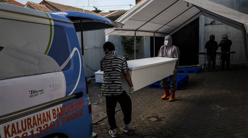 Profissionais de saúde carregam o caixão de uma vítima do COVID-19 em Yogyakarta, Indonésia, 15 de julho de 2021. (Ulet Ifansasti / The New York Times)