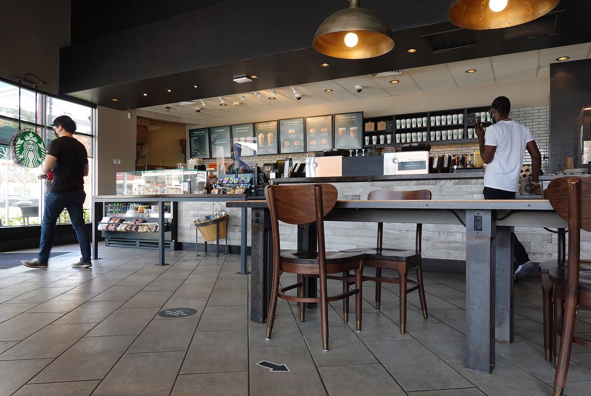 Люди посещают кофейню Starbucks, поскольку компания сообщила о нехватке поставок в некоторых кафе 11 июня 2021 года в Майами, Флорида.