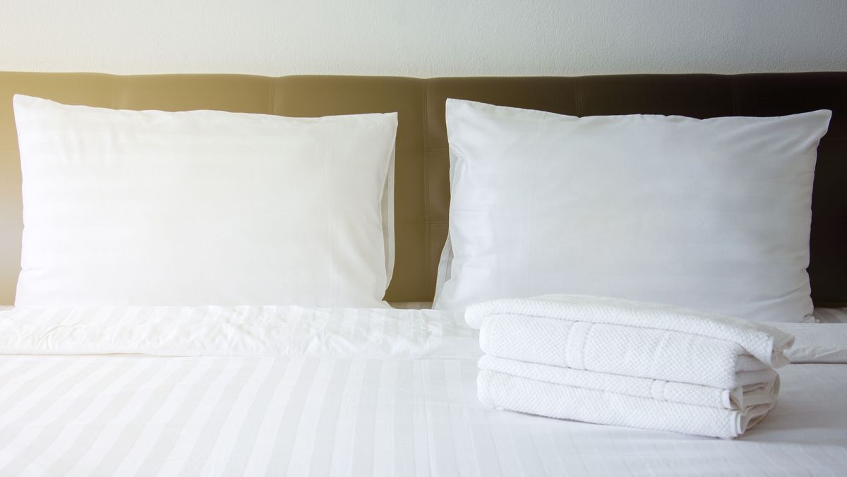 Kissen auf einem Bett mit Handtüchern daneben