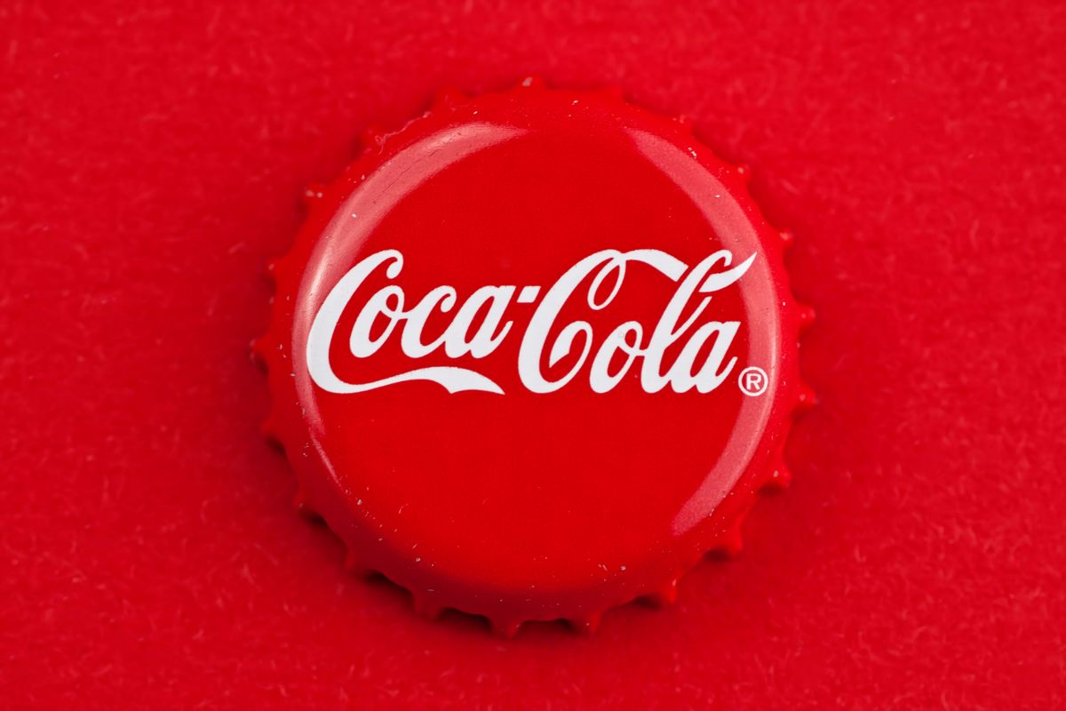 uzáver fľaše coca coly na červenom pozadí