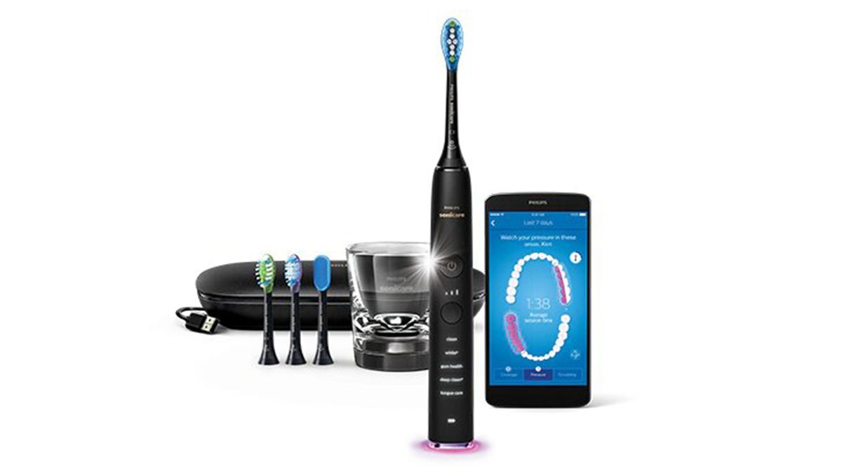 Zobna ščetka Philips 9500 DiamondClean Sonic skupaj s nastavki in zaslonom pametnega telefona, ki prikazuje aplikacijo