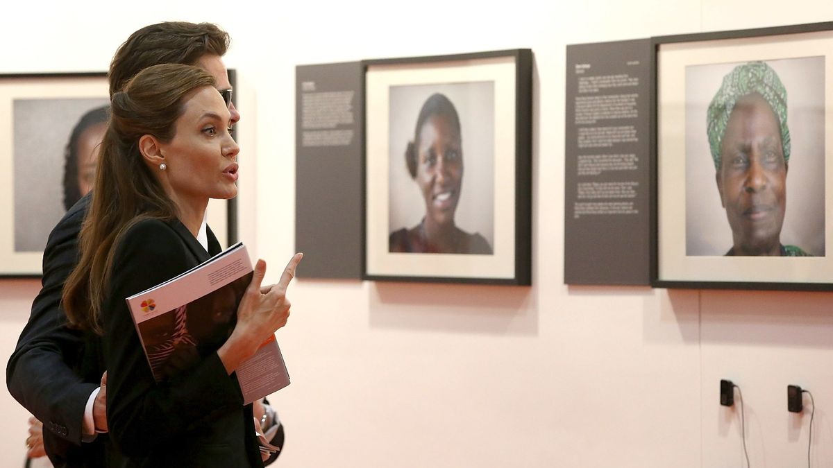 Brad Pitt y la actriz estadounidense y enviada especial de la ONU, Angelina Jolie, observan algunas de las obras de arte expuestas en la Cumbre mundial para poner fin a la violencia sexual en los conflictos en ExCel el 12 de junio de 2014 en Londres, Inglaterra.