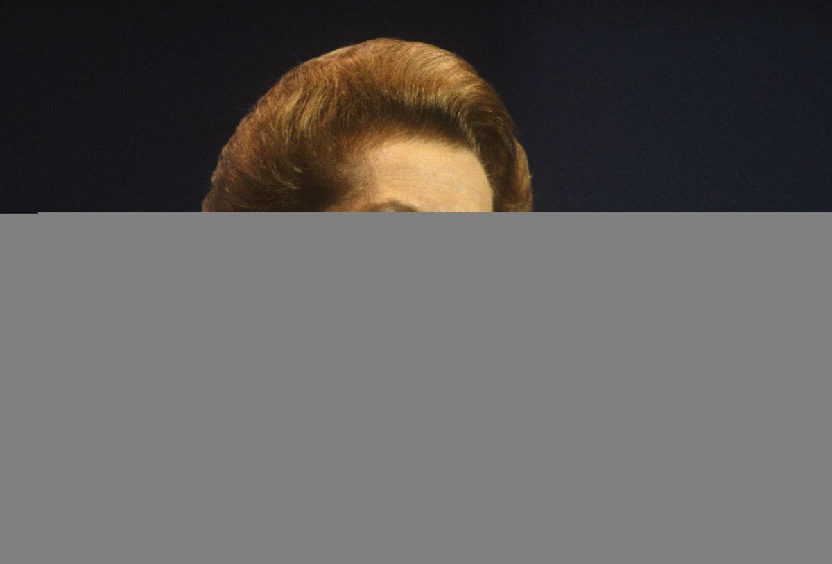 Premierka Margaret Thatcher ima zadnji govor kot predsednica vlade na oktobrski konferenci konservativne stranke oktobra 1990 v Blackpoolu v Lancashireu, nato pa so jo njeni kolegi nekaj tednov zatem odstranili. Njen borbeni duh in strog izraz ji dajeta ugled Iron Lady s pogledom, zaradi katerega se njeni nasprotniki počutijo neprijetno. Oblečena je v najljubšo dvobarvno modro obleko s širokimi rameni in bisernimi uhani. Ambientalne odrske luči poudarjajo blondinke v njenih laseh. (Fotografija avtorja In Pictures Ltd./Corbis prek Getty Images)
