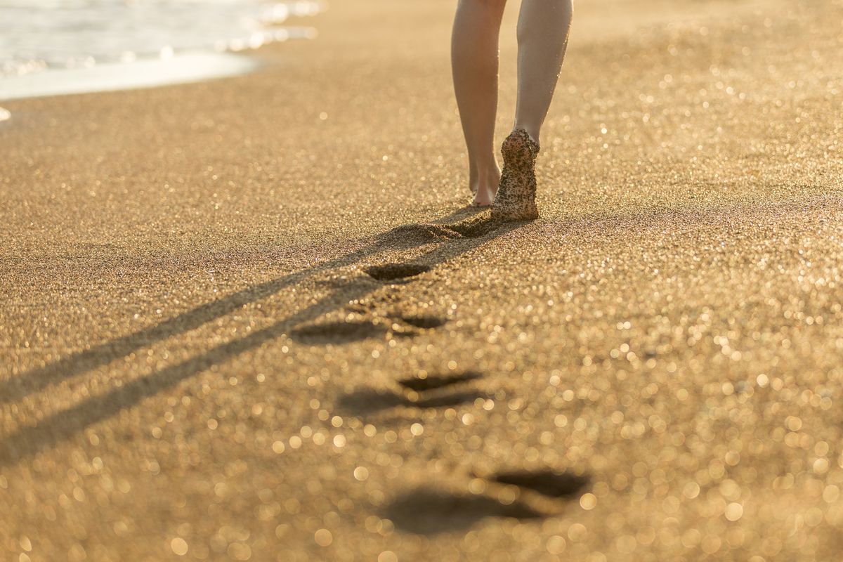 arena en los pies, playa, mujer caminando
