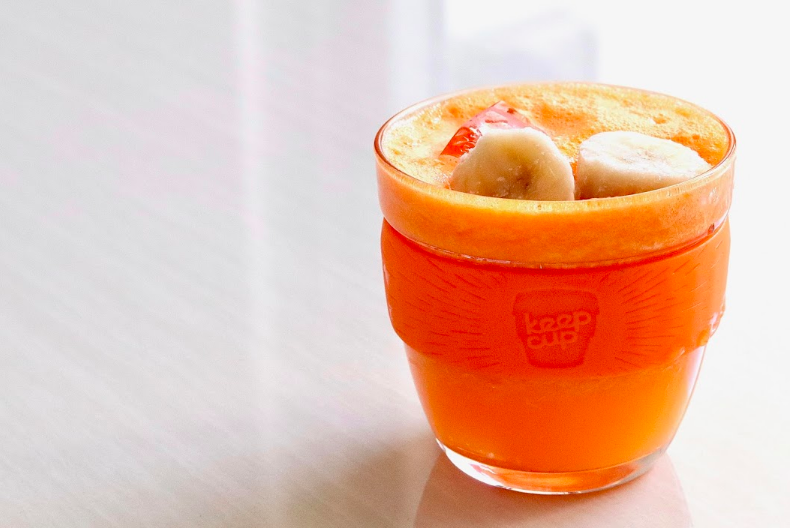 Papájové a banánové smoothie v pohári s posekanou banánovou polevou